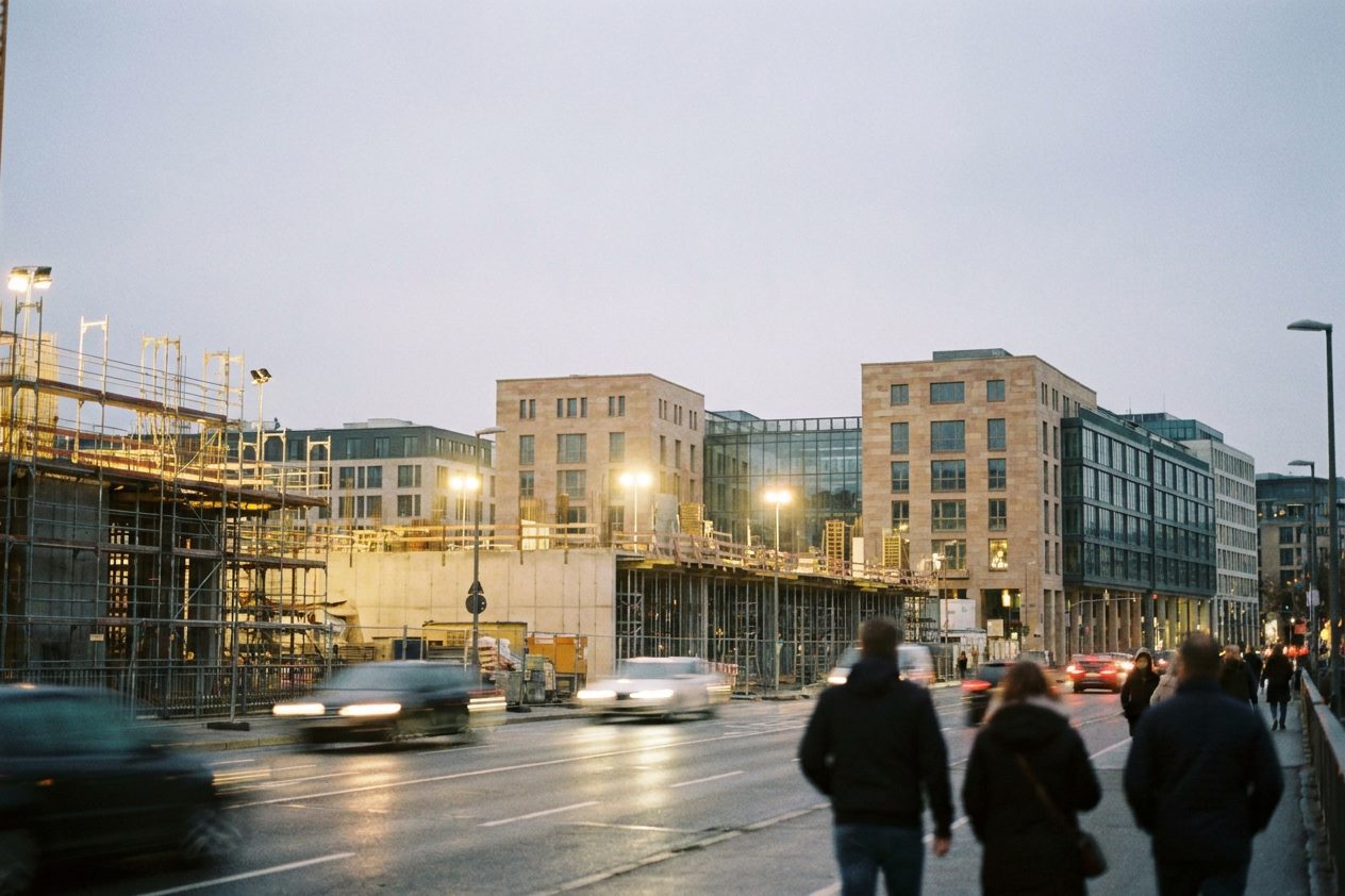 Die hell beleuchtete Baustelle des Central Business Tower in der blauen Stunde, im Vordergrund ziehen Lichtspuren des Abendverkehrs vorbei.