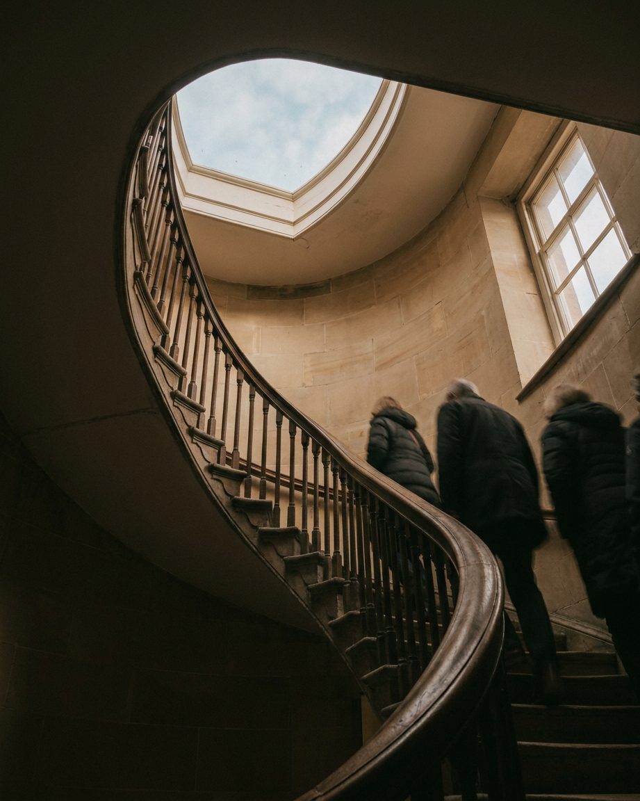 Das geschwungene Treppengeländer im Goethe-Haus, von unten in das helle Oberlicht des Treppenhauses fotografiert.