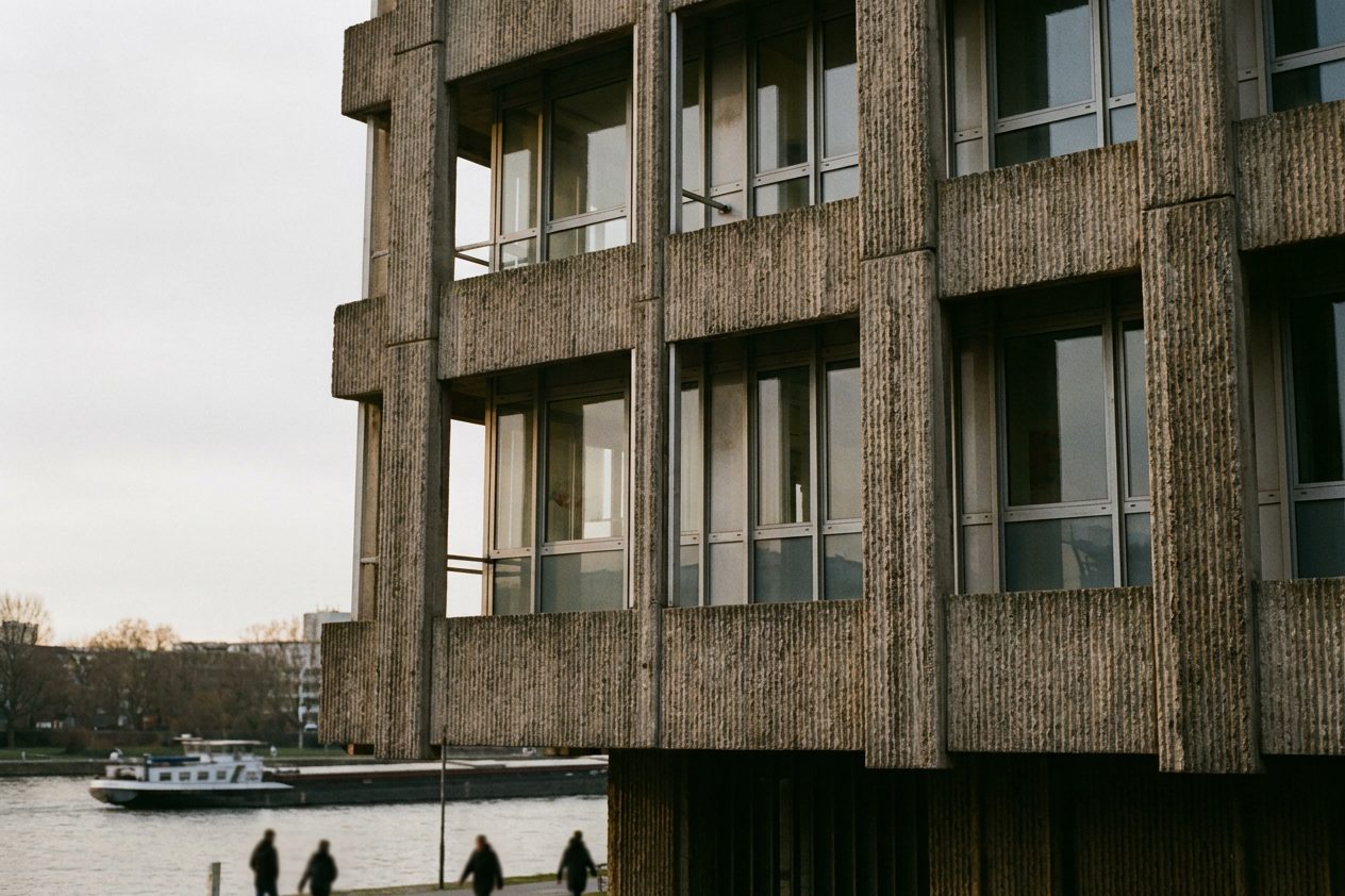 Nahaufnahme der rauen Betonrippen und der gerasterten Fensterbänder an der historischen Fassade der Frankfurter Großmarkthalle.