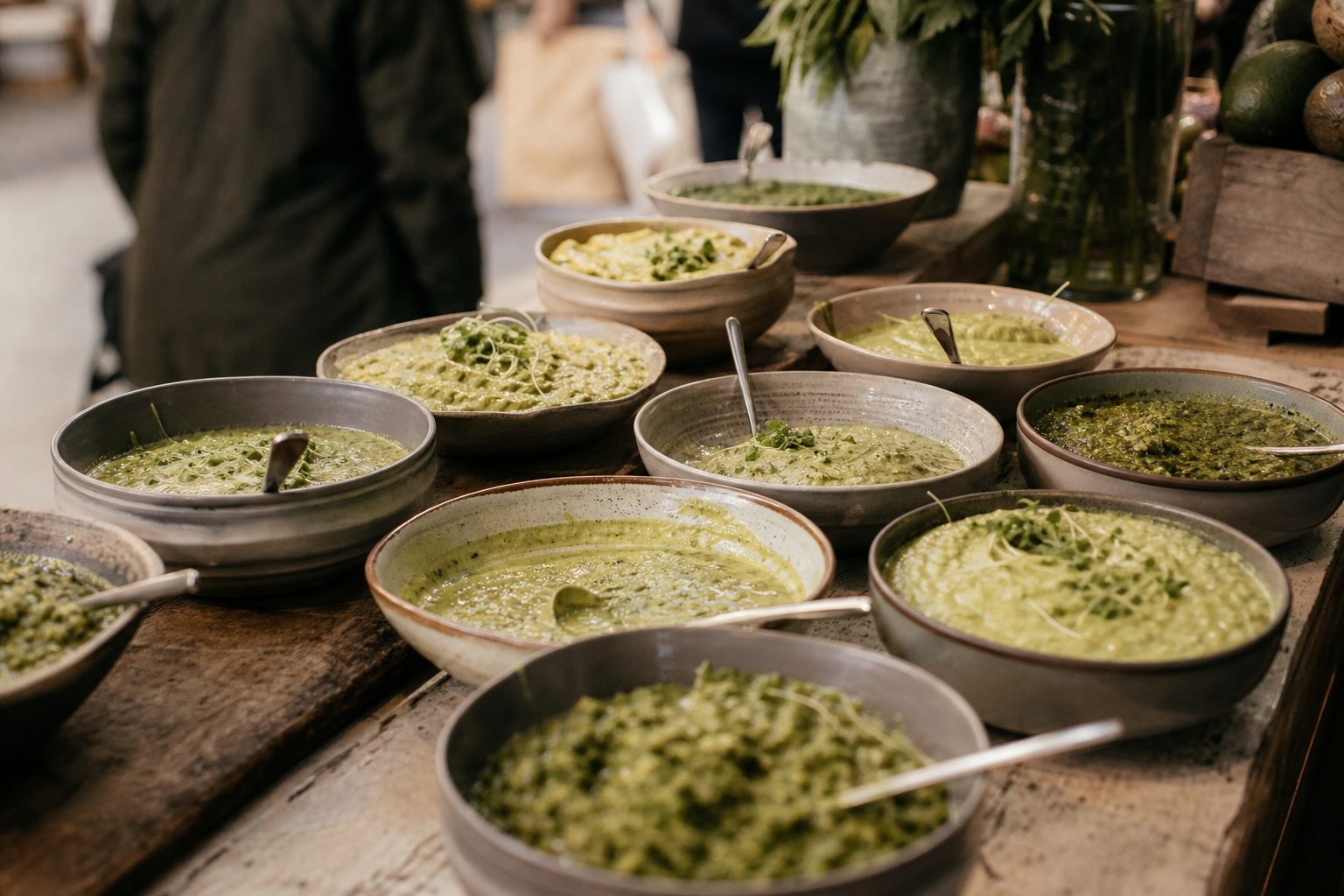 Markttheke mit vielen kleinen Schälchen unterschiedlich grüner Soßen, bereit zur Verkostung.