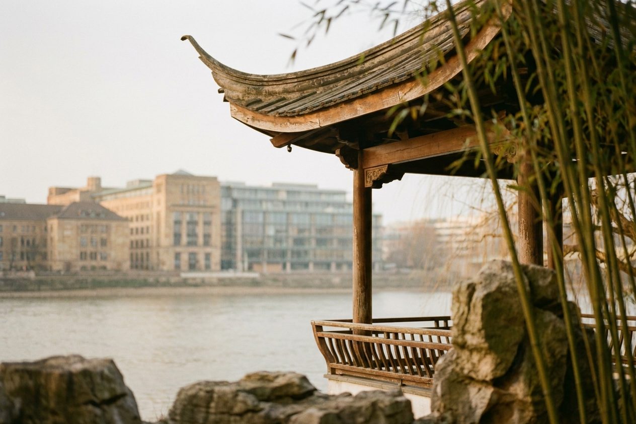 Detail eines geschwungenen Holzpavillons im ostasiatischen Stil zwischen Bambus und Steinen