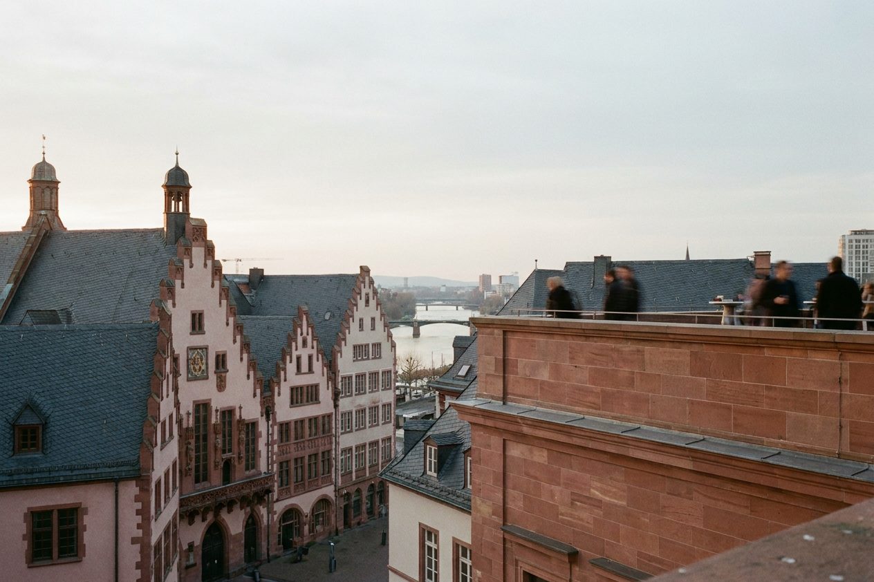 Die Dachlandschaft der Neuen Altstadt vom Domturm aus im Abendlicht, dahinter das Dach des Römers.